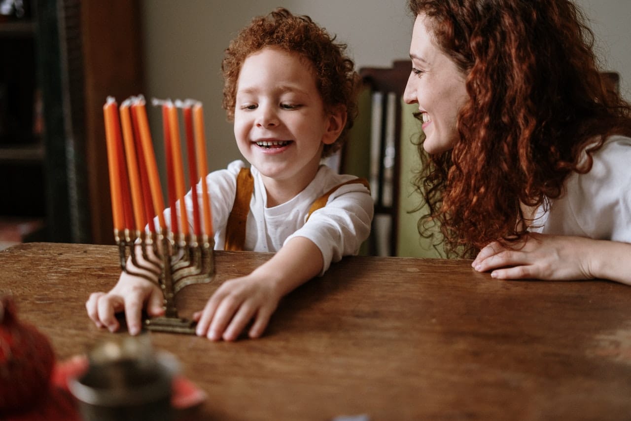 אם ובנו מדליקים נרות חנוכה